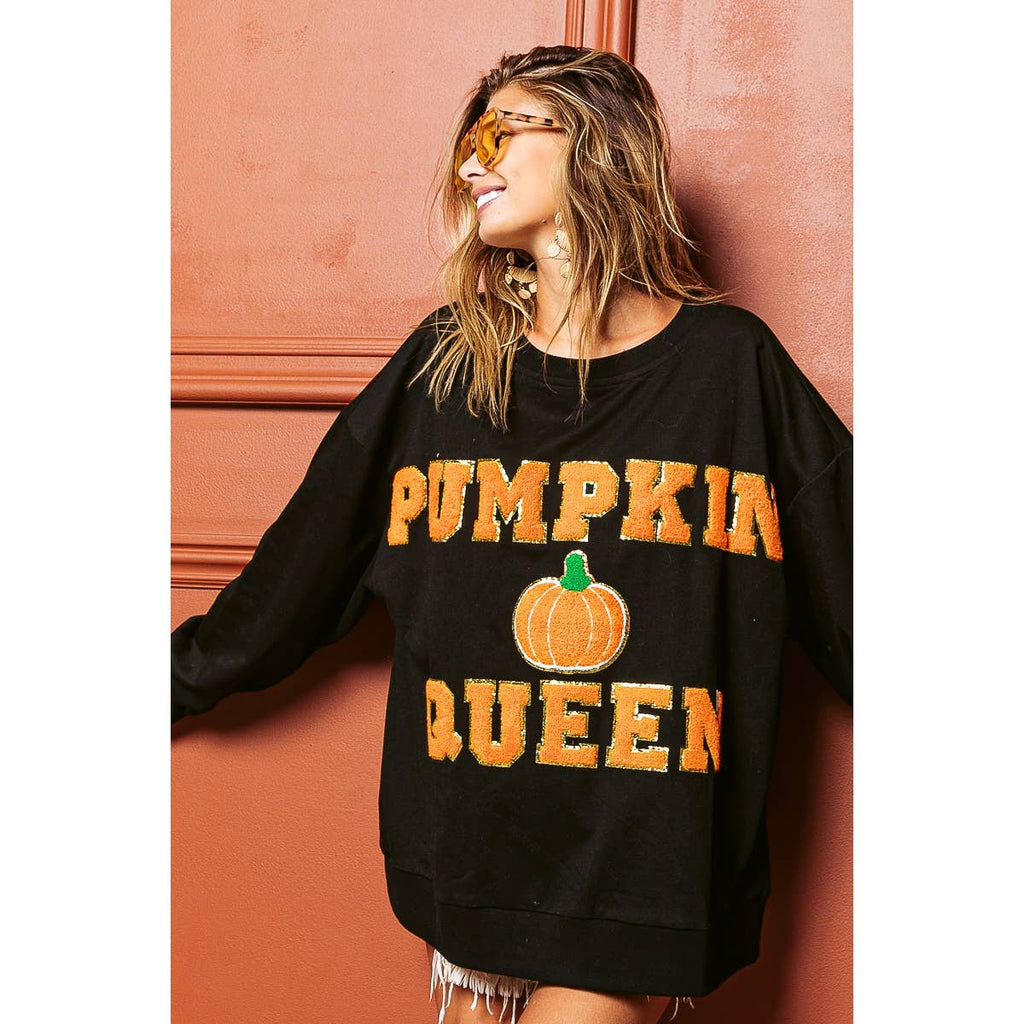 Black sweatshirt with orange "PUMPKIN QUEEN" print and pumpkin graphic, angled