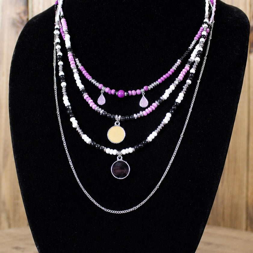 Multi-strand magenta and silver beaded necklace with teardrop charms and large round pendant