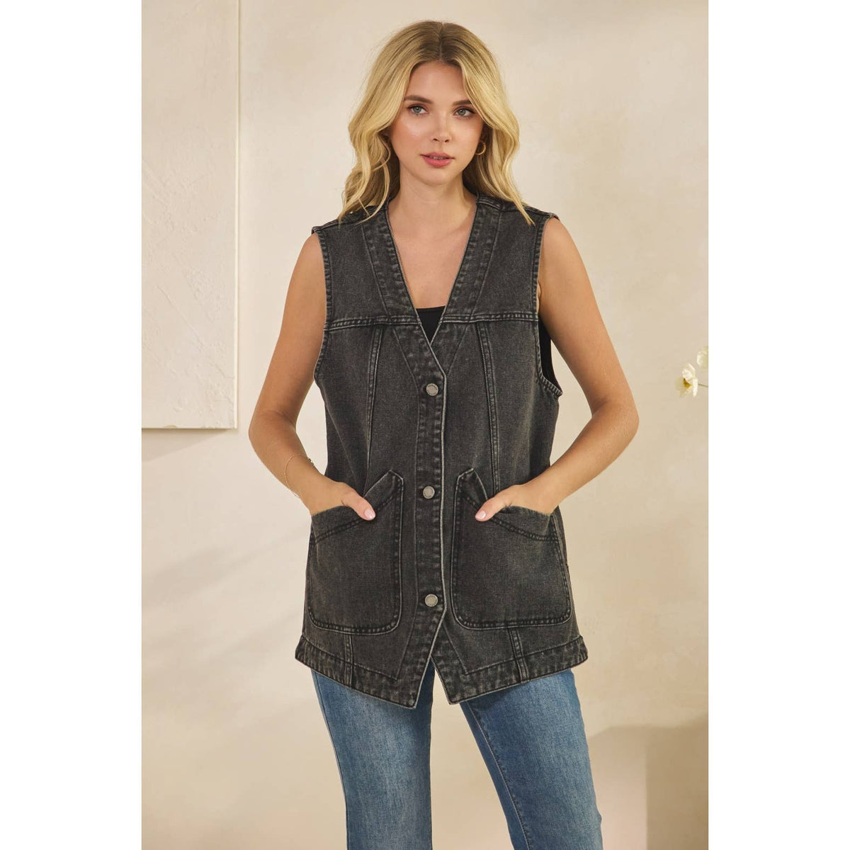 Dark wash denim sleeveless vest with V-neck, two front patch pockets, button closure