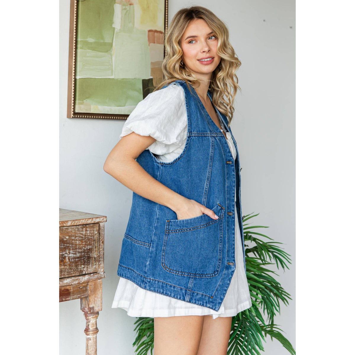 Medium-wash denim vest with front patch pockets and buttoned placket