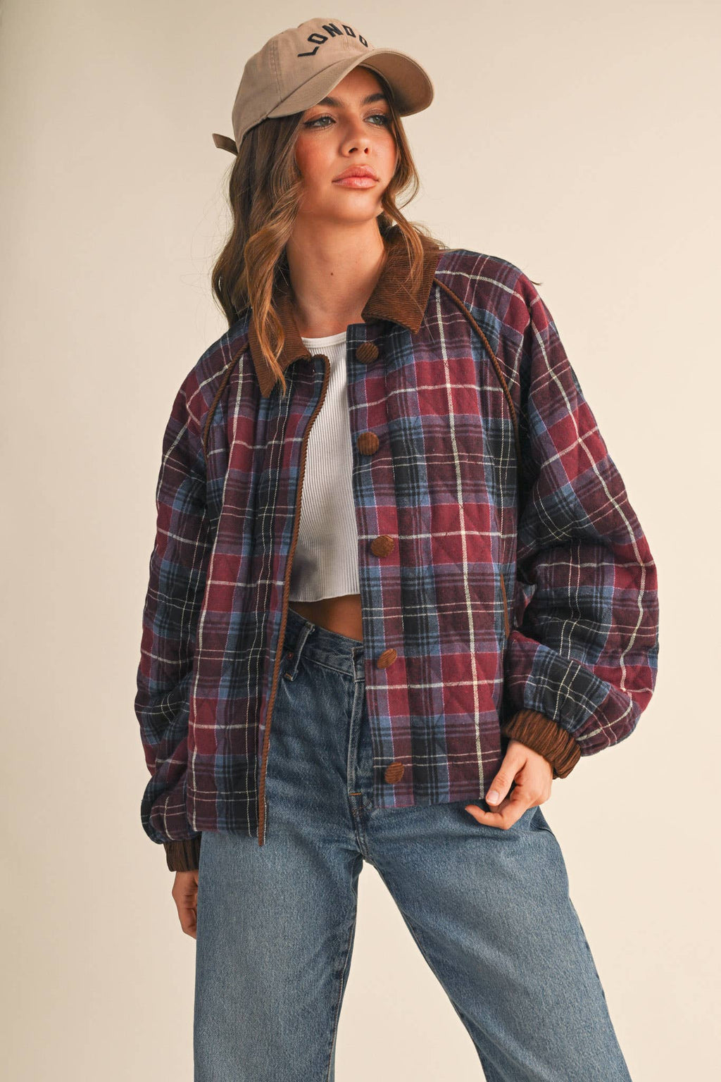 Plaid quilted jacket with corduroy-trim stand collar, button front, and side pockets.