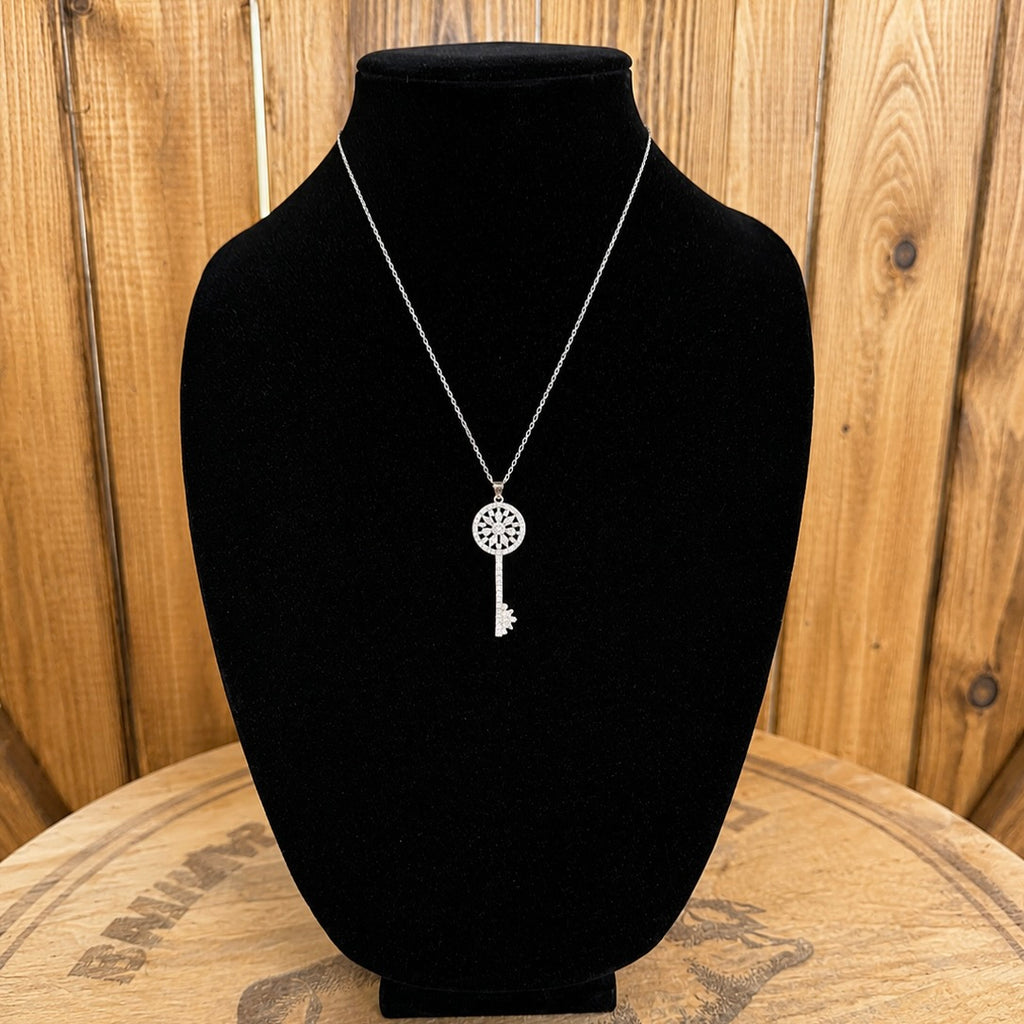Silver-tone crystal key necklace with circular crystal bezel and key charm