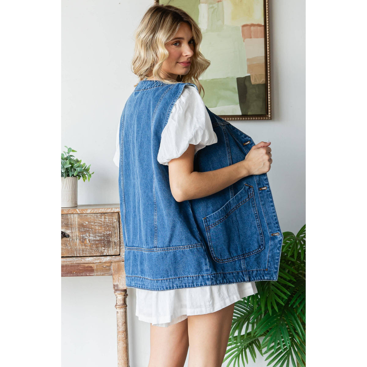 Medium-wash denim vest shown from the back with large patch pocket details