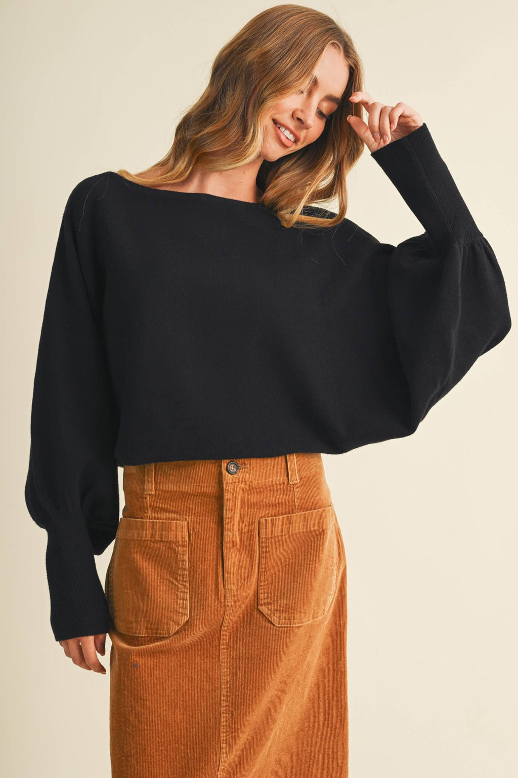 Black dolman pullover with wide sleeves and bateau neckline, worn with brown corduroy pants.
