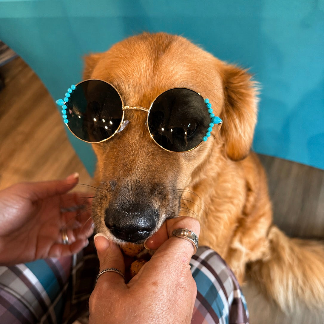 Turquoise sunglasses with black round lenses and teal bead detailing along the rims