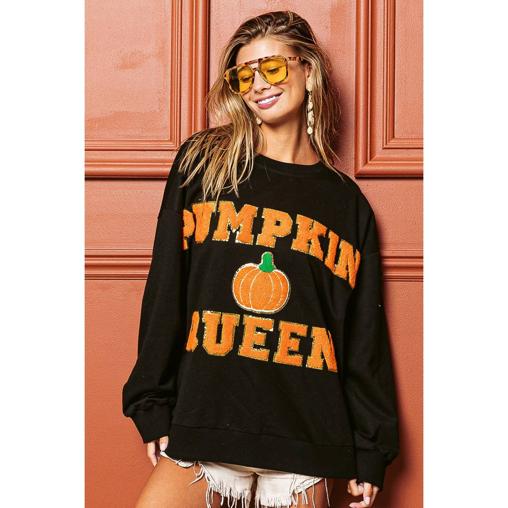 Black sweatshirt with orange "PUMPKIN QUEEN" lettering and pumpkin graphic