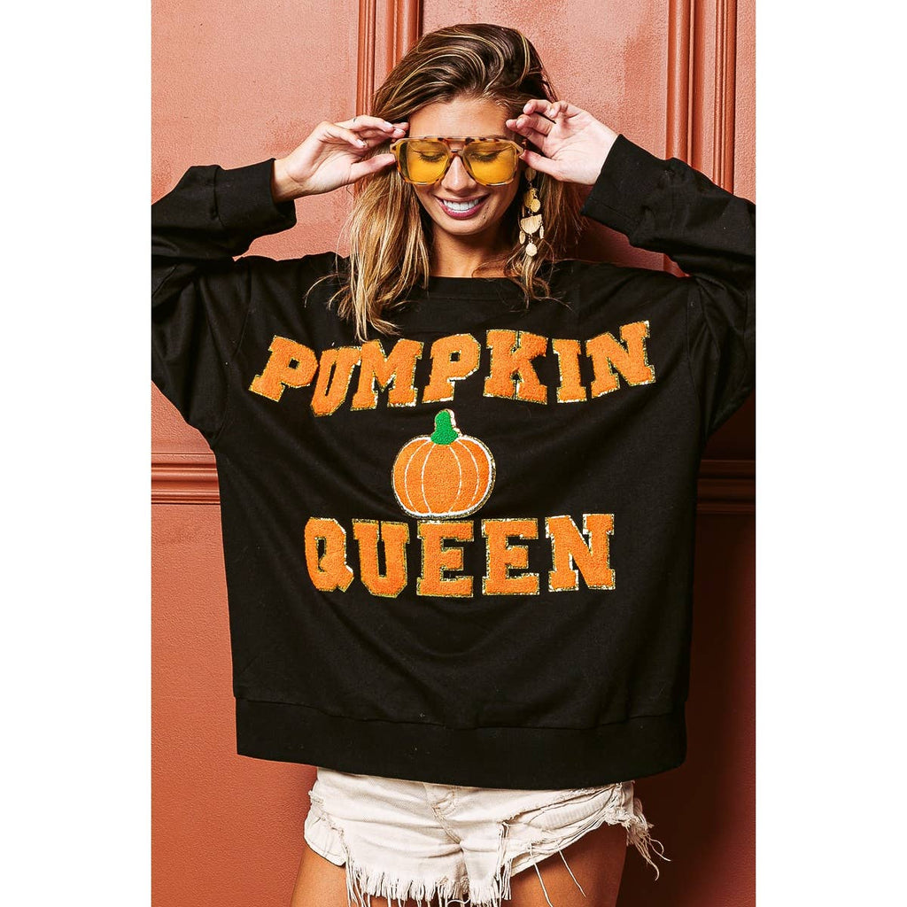 Black sweatshirt with bold “PUMPKIN QUEEN” lettering and pumpkin graphic, relaxed fit