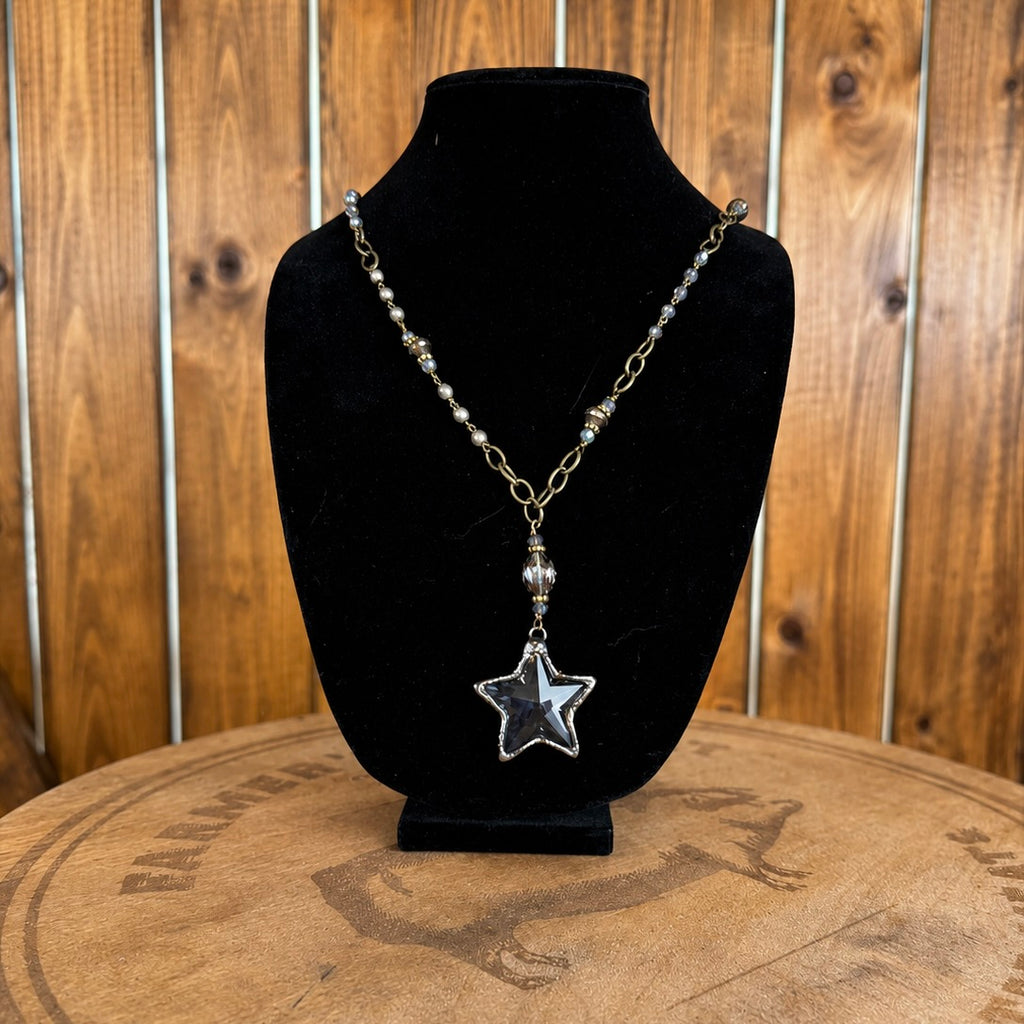 Star pendant necklace with gold-tone chain and dangling beads, medium blue stone center
