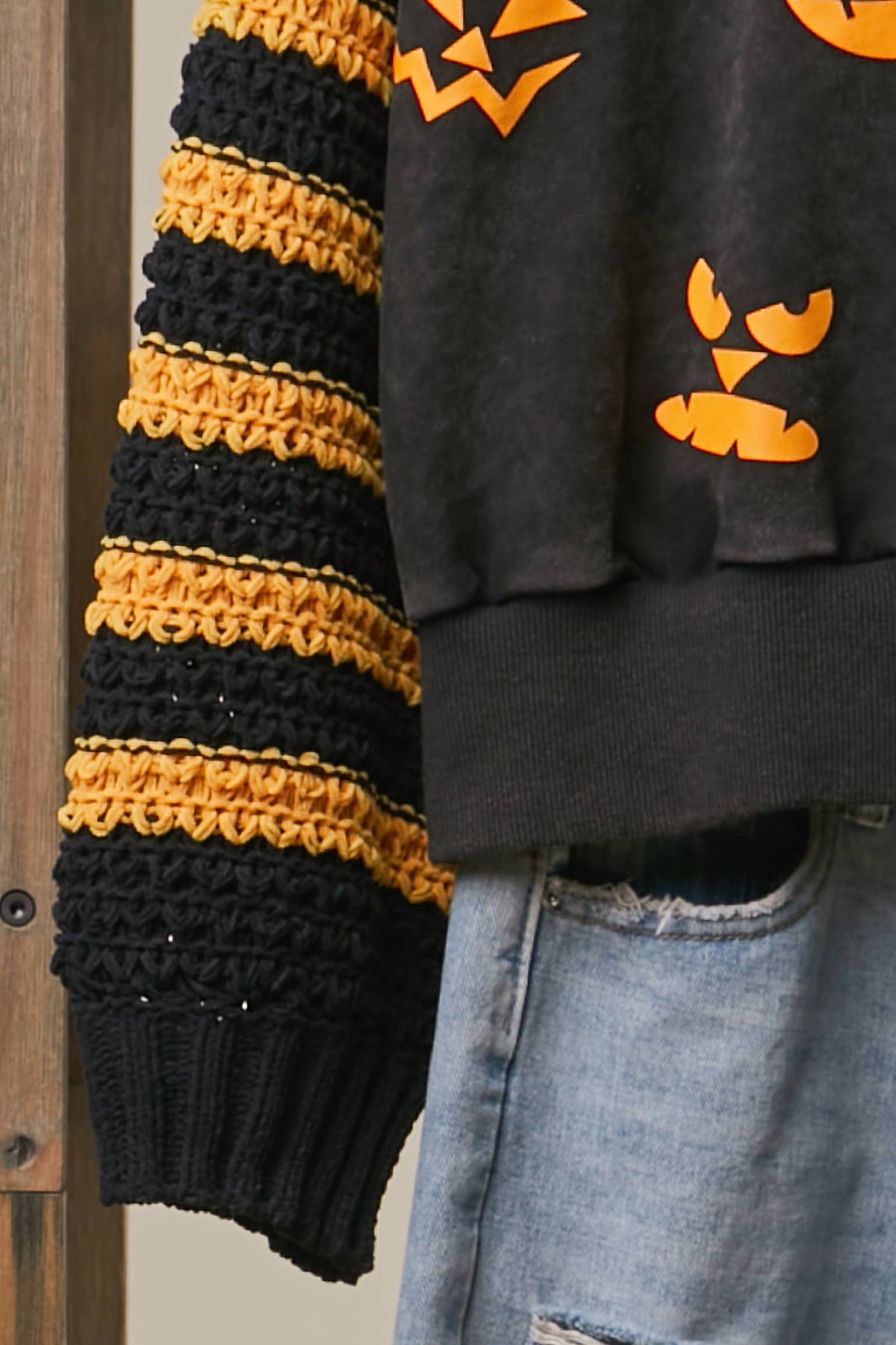 Black knit top with yellow-and-black striped sleeve and ribbed hem