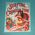 Maroon graphic T-shirt with "Surfing the Crimson Tide" text and surfer woman on board