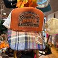 Embroidered trucker cap with orange front panel and blue plaid brim, mesh sides