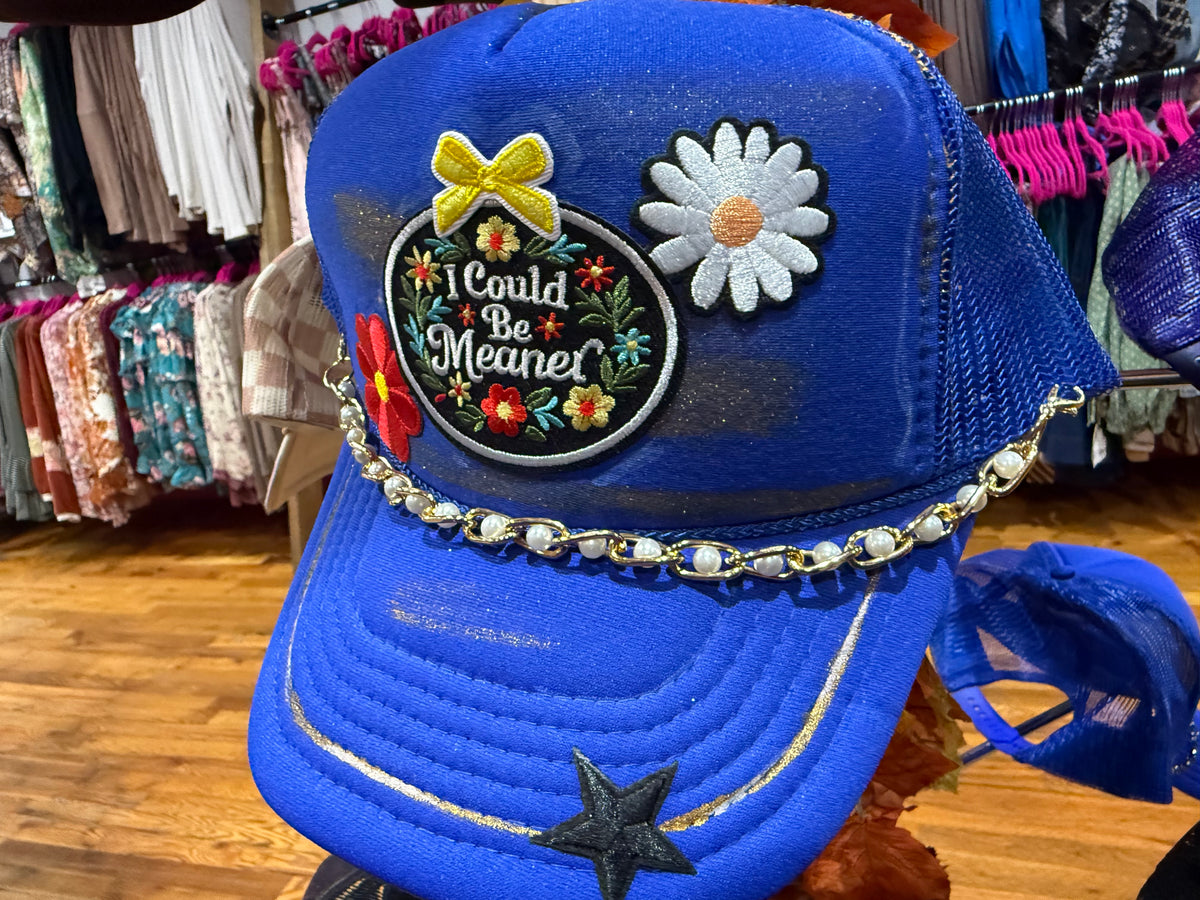 Blue baseball cap with embroidered patches and beaded chain trim; front star detail