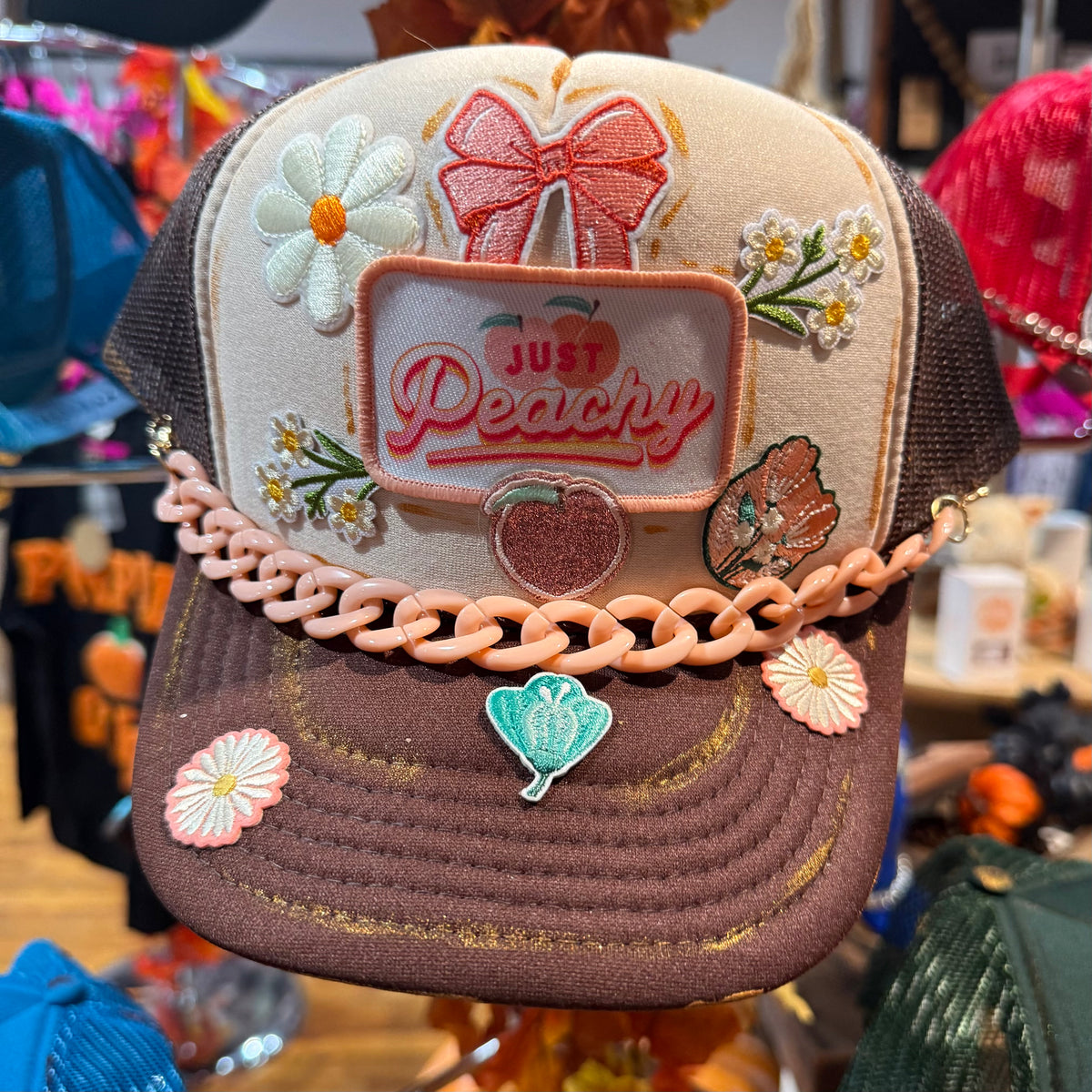 Embroidered baseball cap with floral butterfly patches and chunky chain detail
