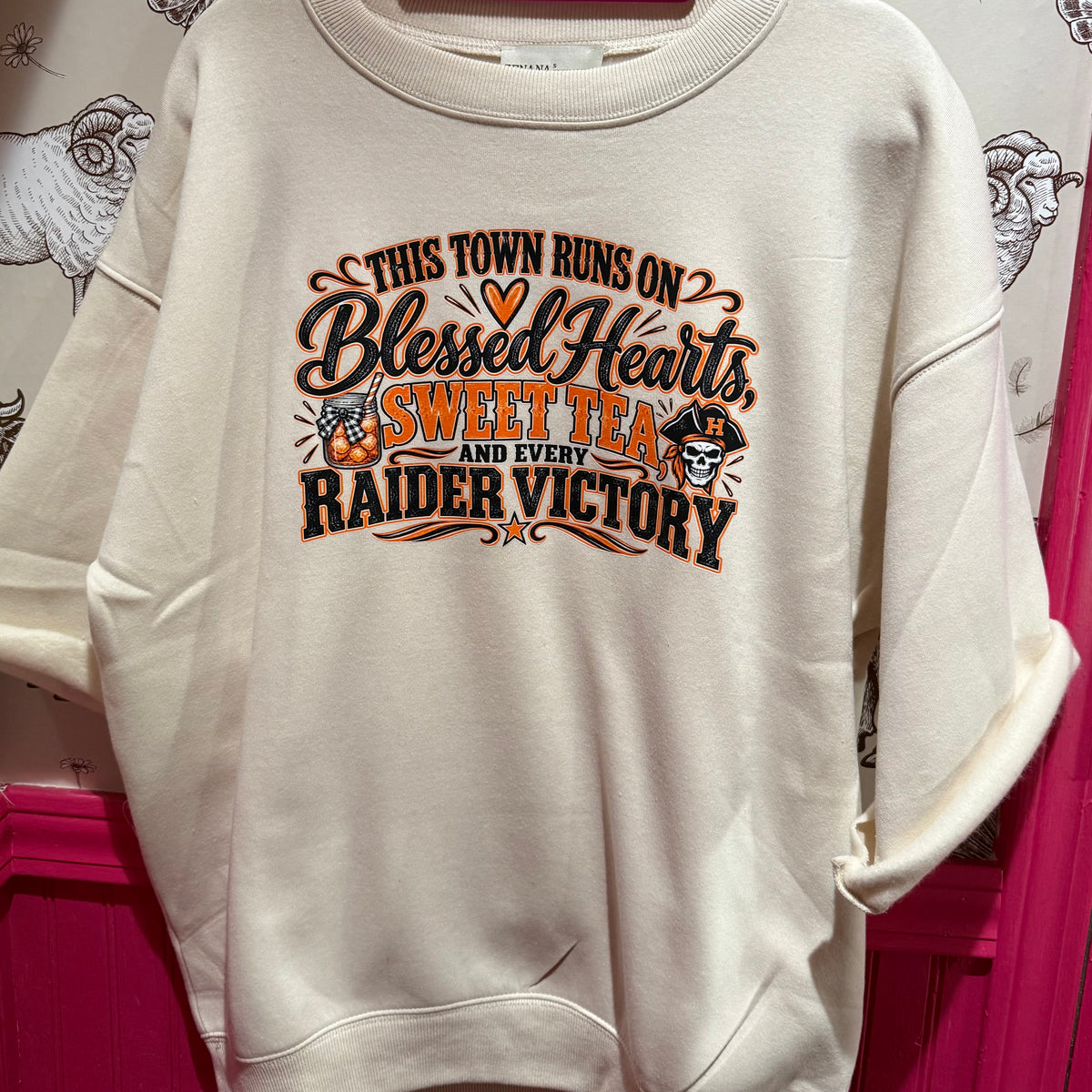 Cream crewneck sweatshirt with Raider victory 'Blessed Hearts' front graphic