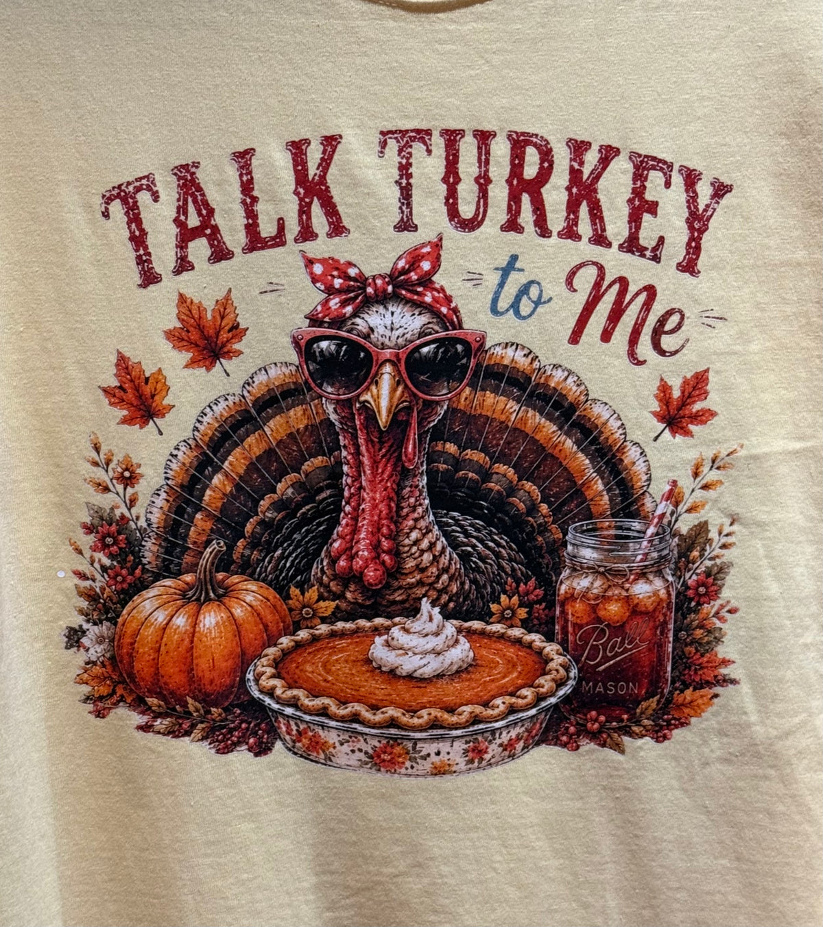 Cream T-shirt front with turkey in sunglasses, pumpkins, pie, and maple leaves art