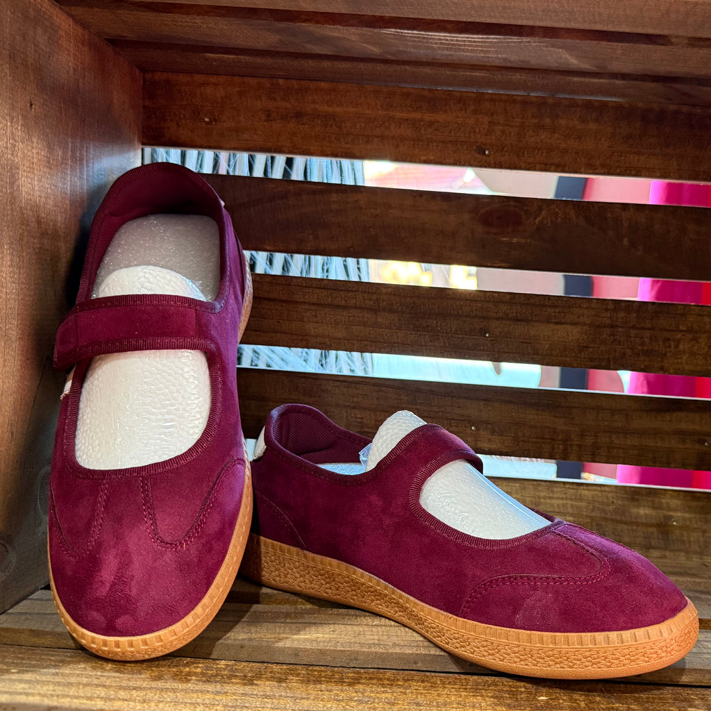Burgundy suede slip-on shoes with adjustable hook-and-loop strap and tan rubber sole