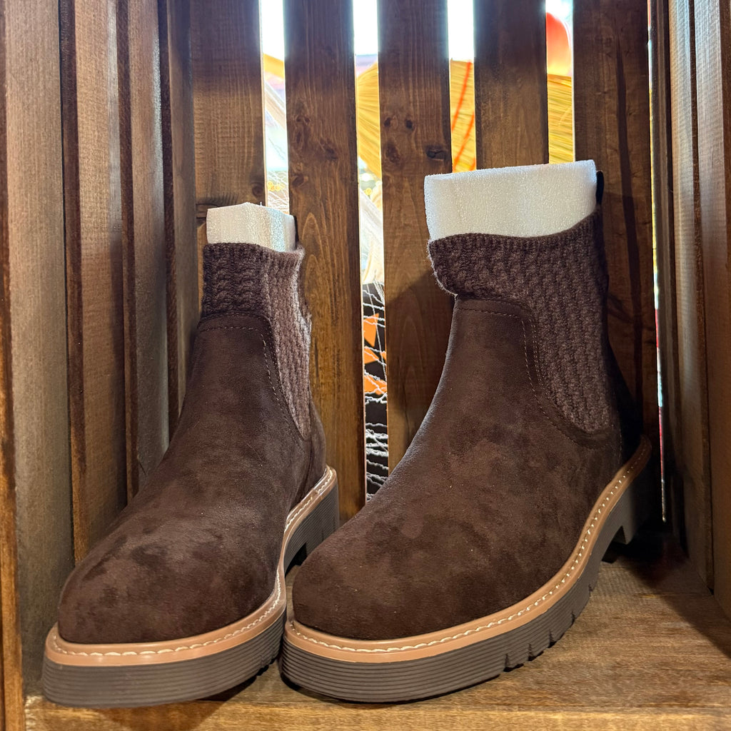 Pair of chocolate faux suede ankle boots with knit cuffs, tan welt stitching, lug sole