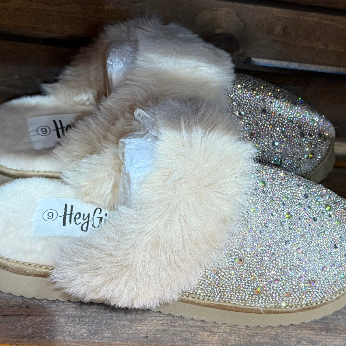 Pair of light glitter slip-on slippers with white faux-fur straps and stitched sole