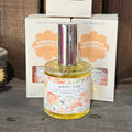 Warm + Cozy eau de parfum bottle, gold cap, floral label, 50 ml