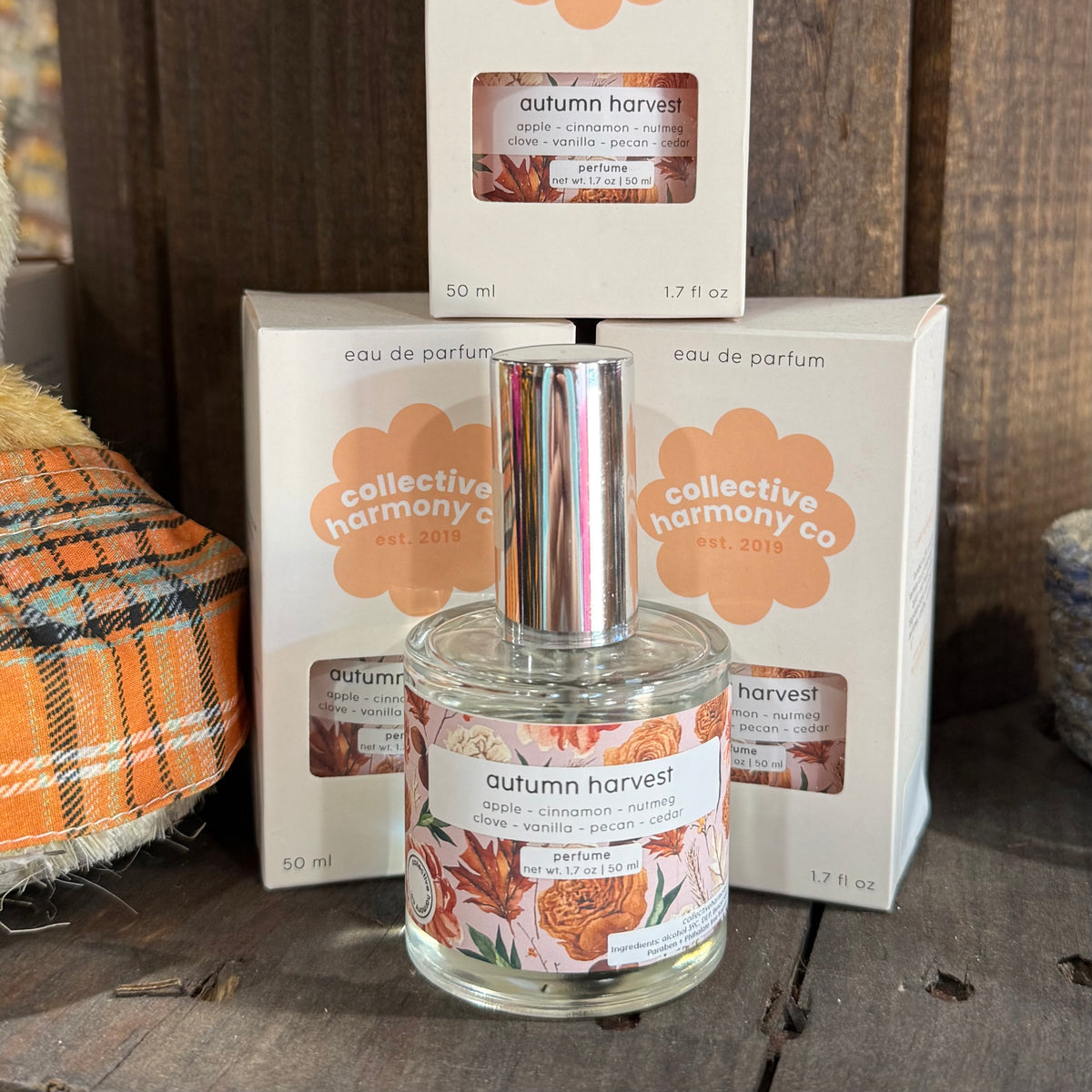Clear glass eau de parfum bottle with illustrated autumn label and matching box