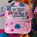 Pink trucker hat with checkered bow, bow applique, and “Too Tired for this” graphic patch