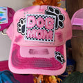 Pink trucker hat with embroidered 'Dog Mom' patch and paw-print accents, mesh back