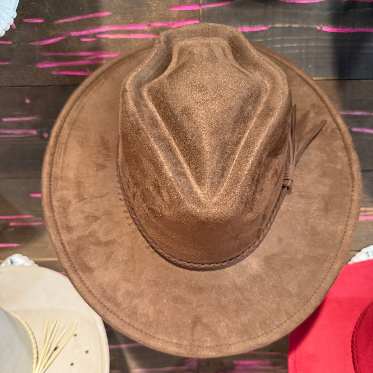 Dark brown arrow-shaped hat with wide brim and textured crown panel
