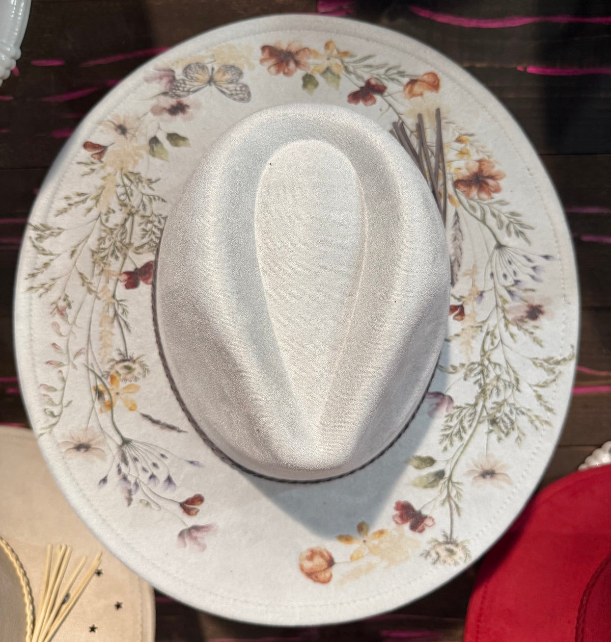 Light grey wide-brim hat with floral print band and curved brim edge