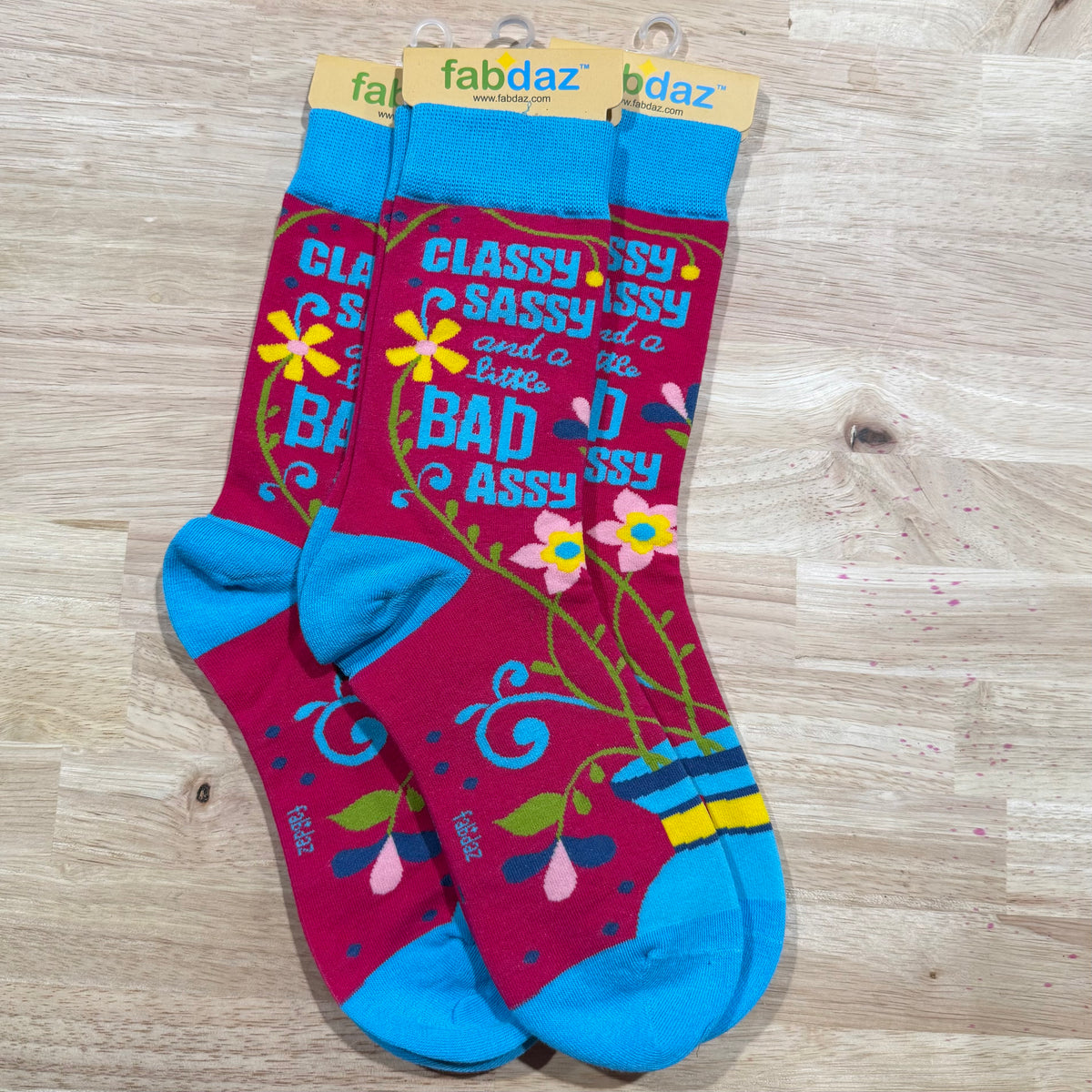 Blue and magenta crew socks with “CLASSY SASSY” and “BAD ASS” lettering