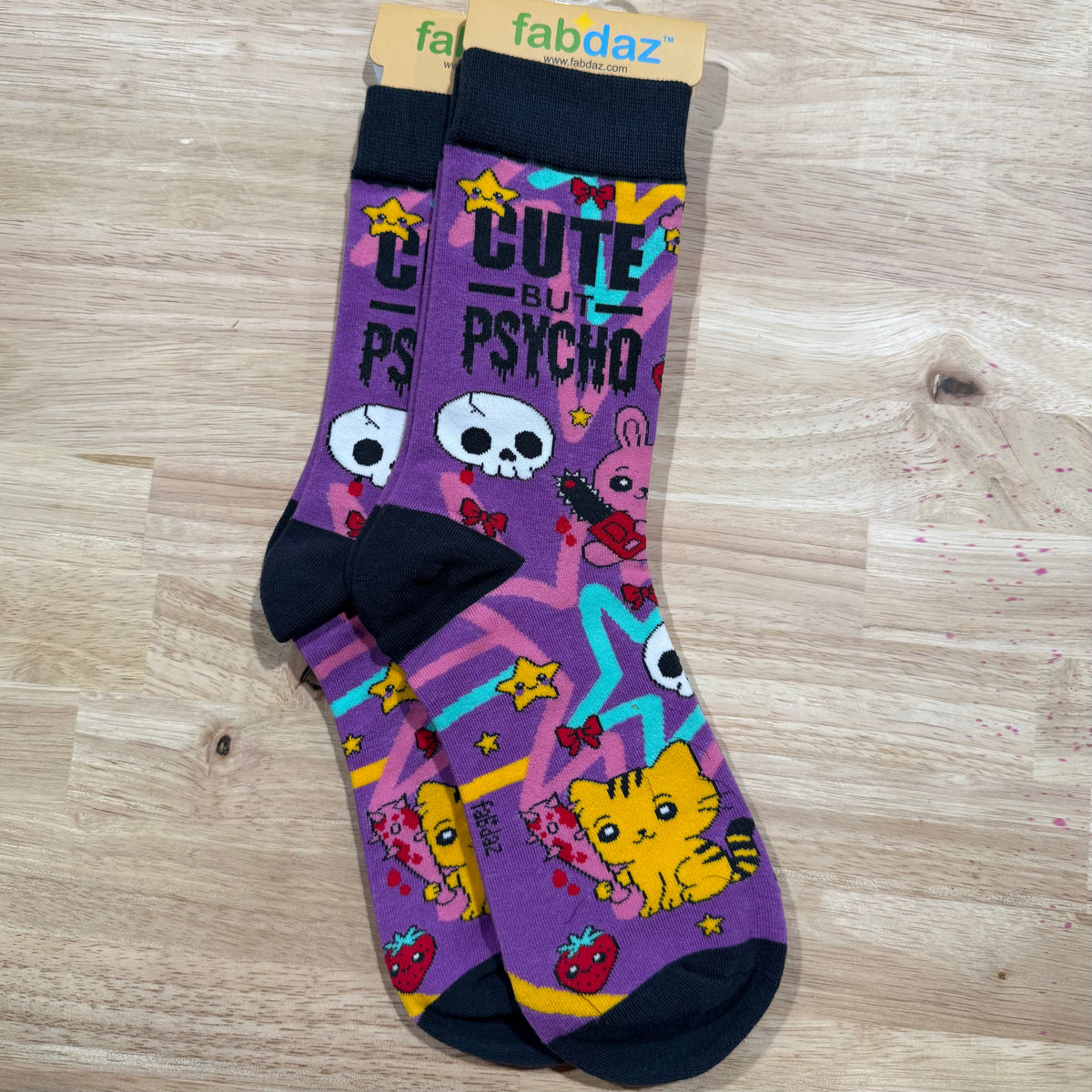 Funny socks with purple cat and skull graphics, stars, and text 'Cute But Psycho'.