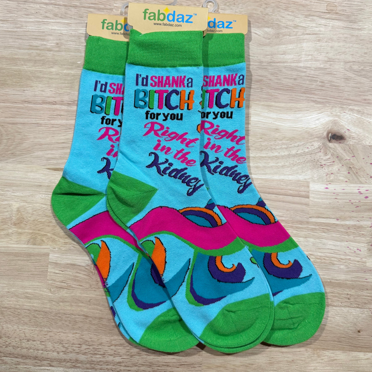 Green and blue crew socks with “BITCH” text and colorful swirls and shapes