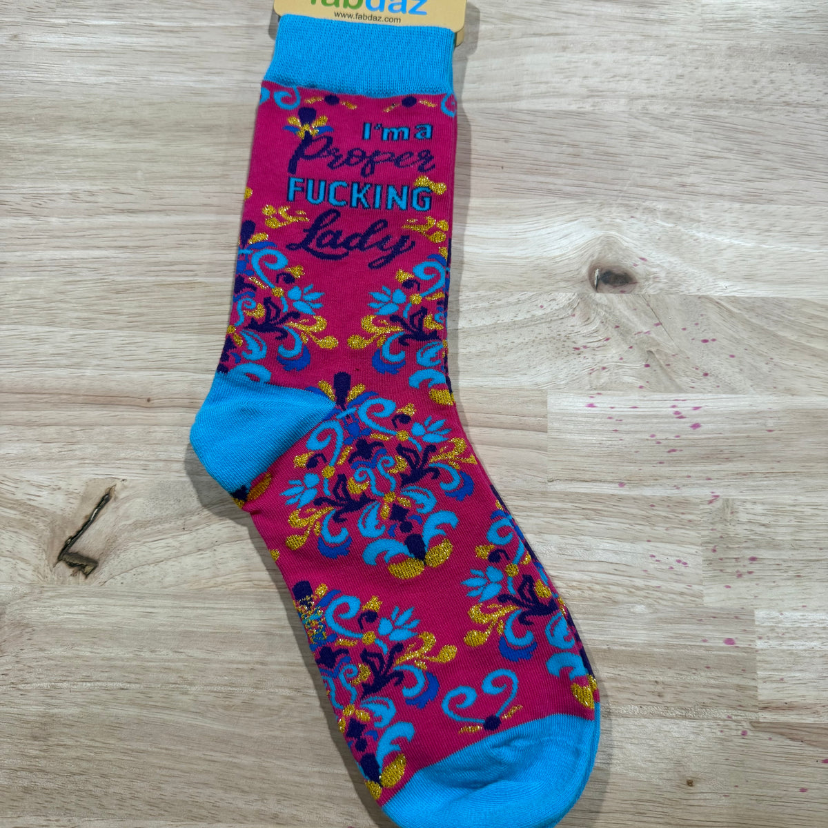 Colorful floral adult novelty socks with blue cuff and bold lettering on maroon panels