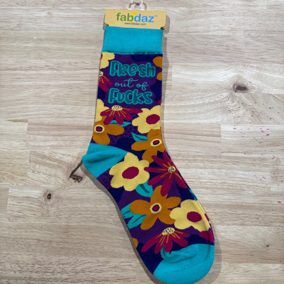Colorful floral adult novelty socks with blue heel and foot lettering and flower patterns