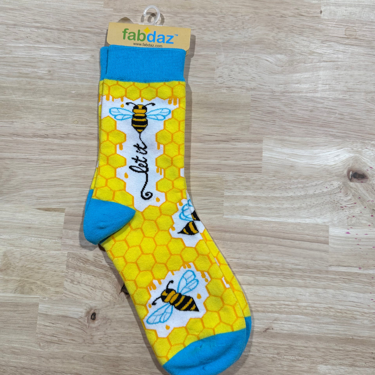 Funny socks with yellow honeycomb pattern, blue cuffs, and bee graphic.