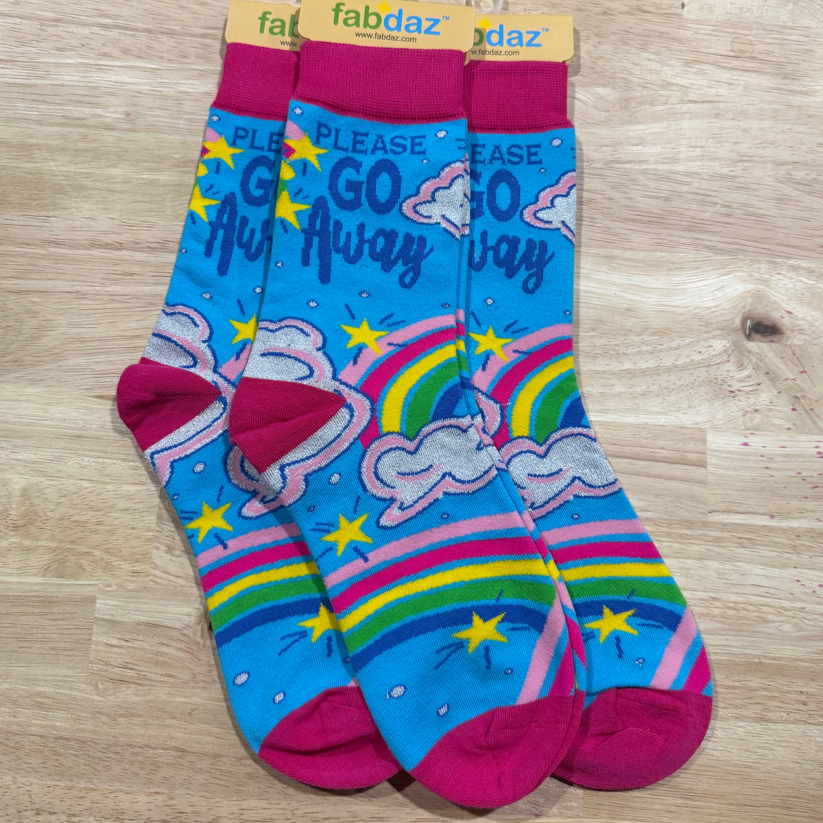 Funny socks with blue and purple rainbow and clouds and text 'Please Go Away'.