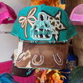 Turquoise trucker hat with embroidered patches, beaded trim, and brown front panel