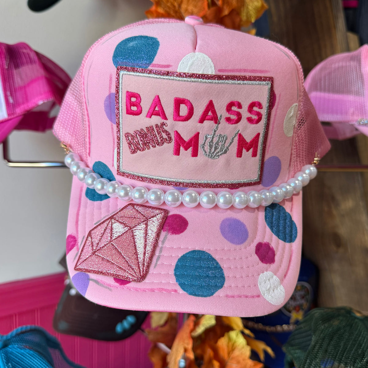 Pink mesh cap with 'BADASS BONUS MOM' patch and pearl trim