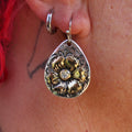 Teardrop gold flower metal earrings with clear rhinestone center and hanging hook.