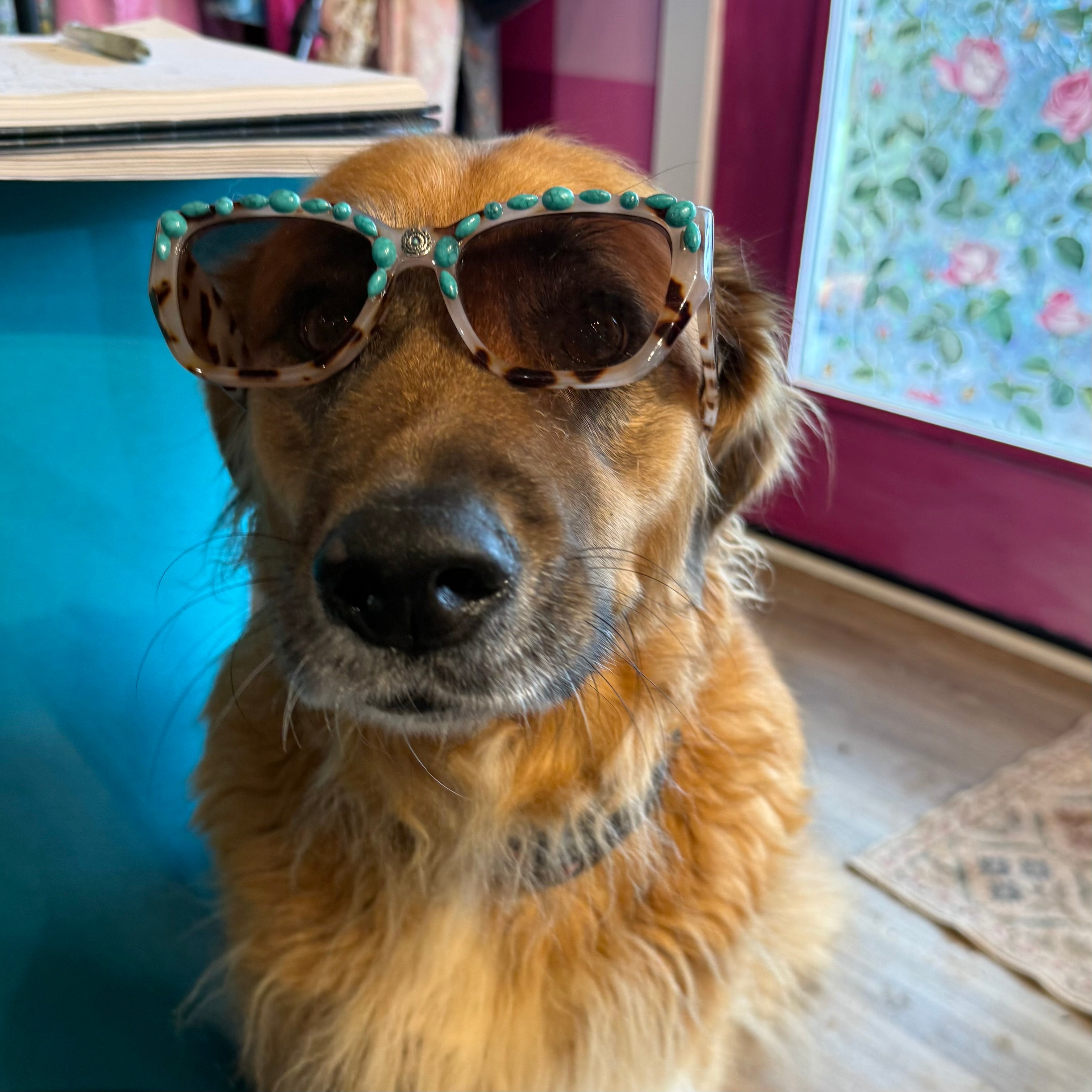 Turquoise sunglasses with dark round lenses and teal beads on the frame corners