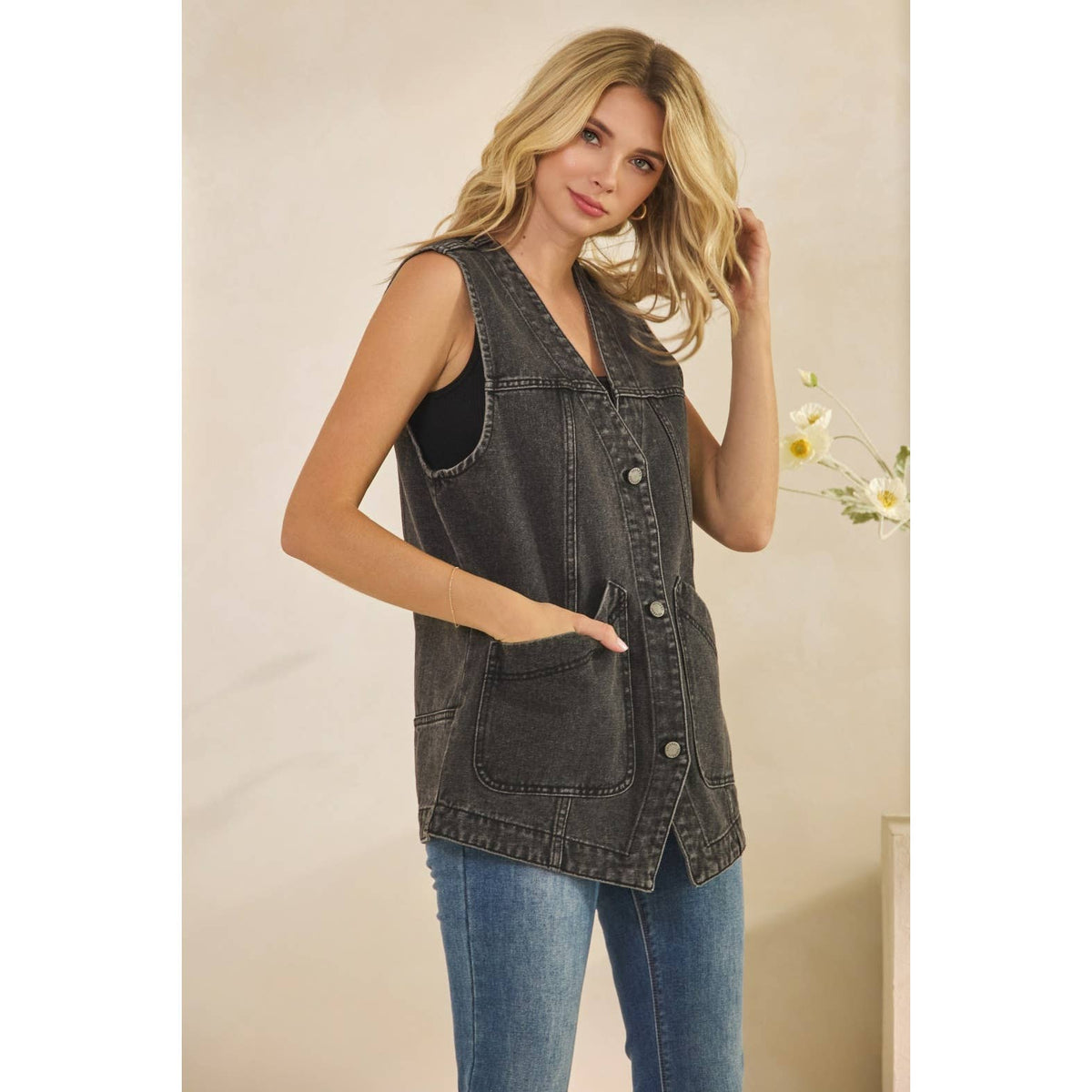 Dark wash denim sleeveless vest with V-neck, front patch pocket, and button placket