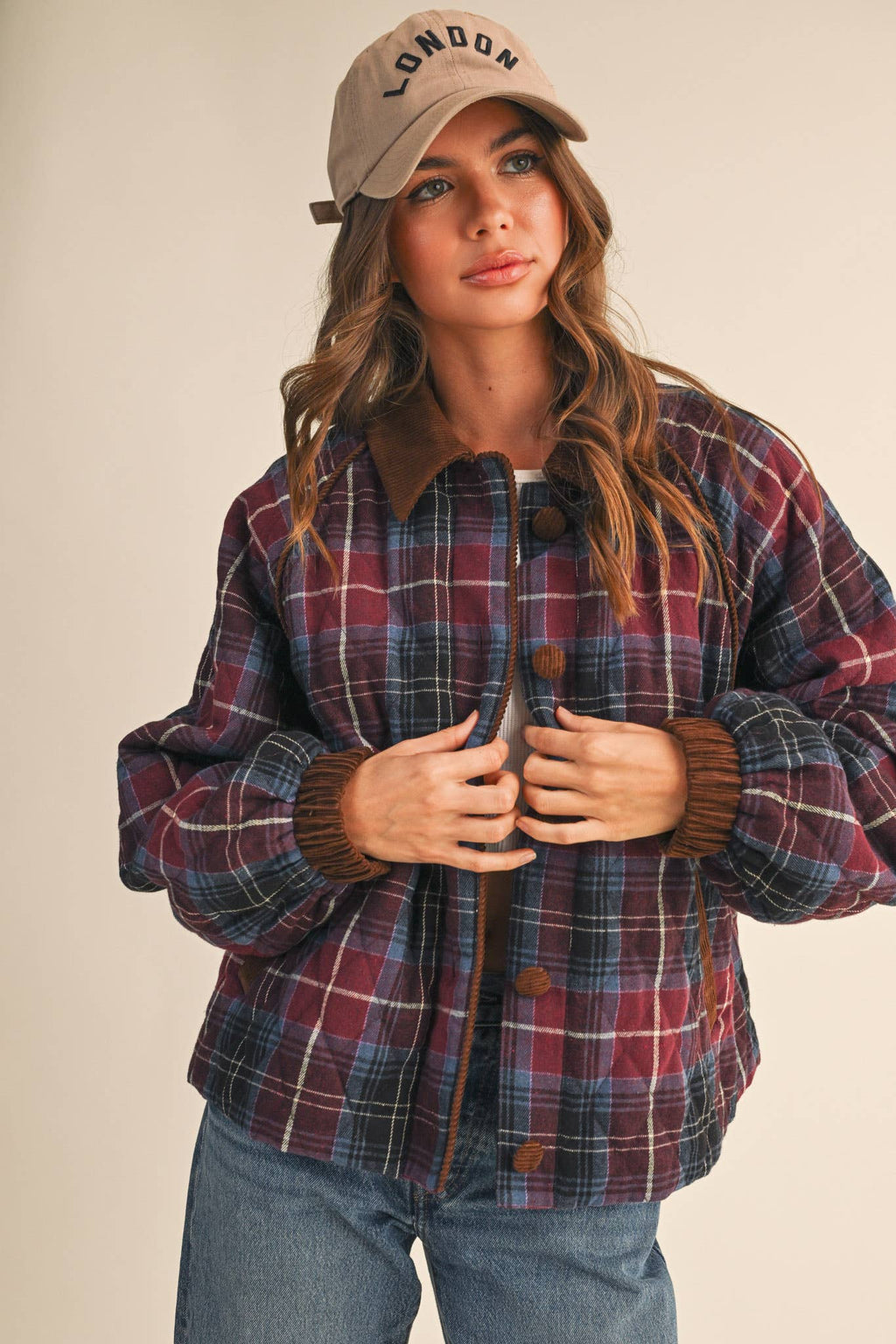 Plaid quilted jacket with corduroy-trim placket and cuffs; dark buttons down center.