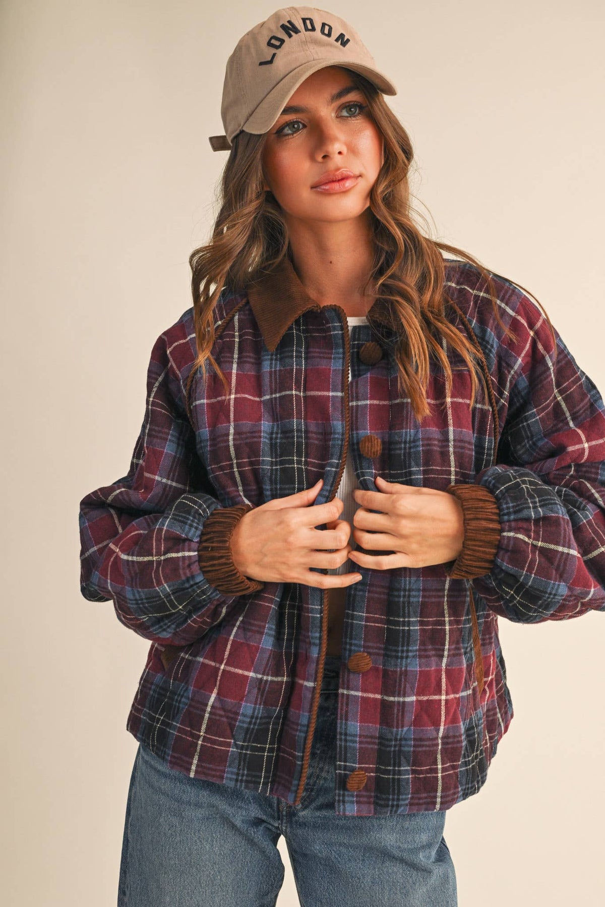 Plaid quilted jacket with corduroy-trim placket and cuffs; dark buttons down center.