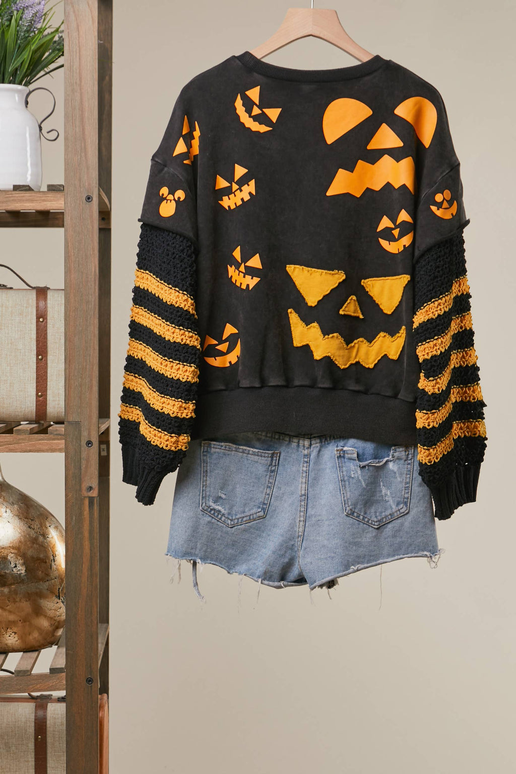 Black top with back Halloween print, striped sleeves, ribbed neckline
