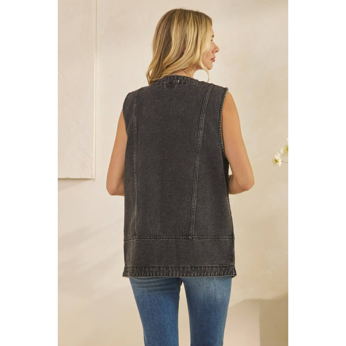 Dark denim vest back with yoke seams and curved hem