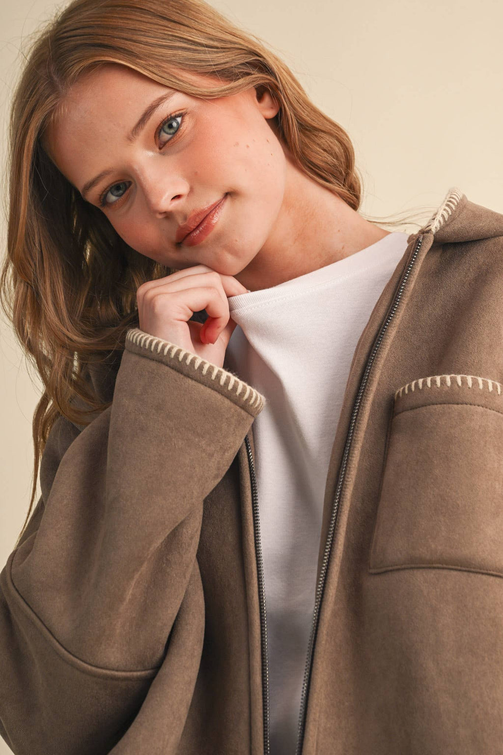 Taupe hooded jacket detail with contrasting blanket-stitch trim and sherpa lining