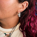 Silver hoop earrings with sparkling pave stones, side view on ear