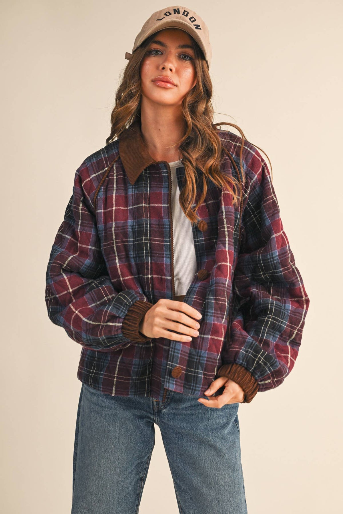 Multi plaid quilted jacket with dark corduroy-trim collar, button placket, and long sleeves.