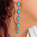 Turquoise teardrop dangle earrings with silver-tone links and scalloped bezels