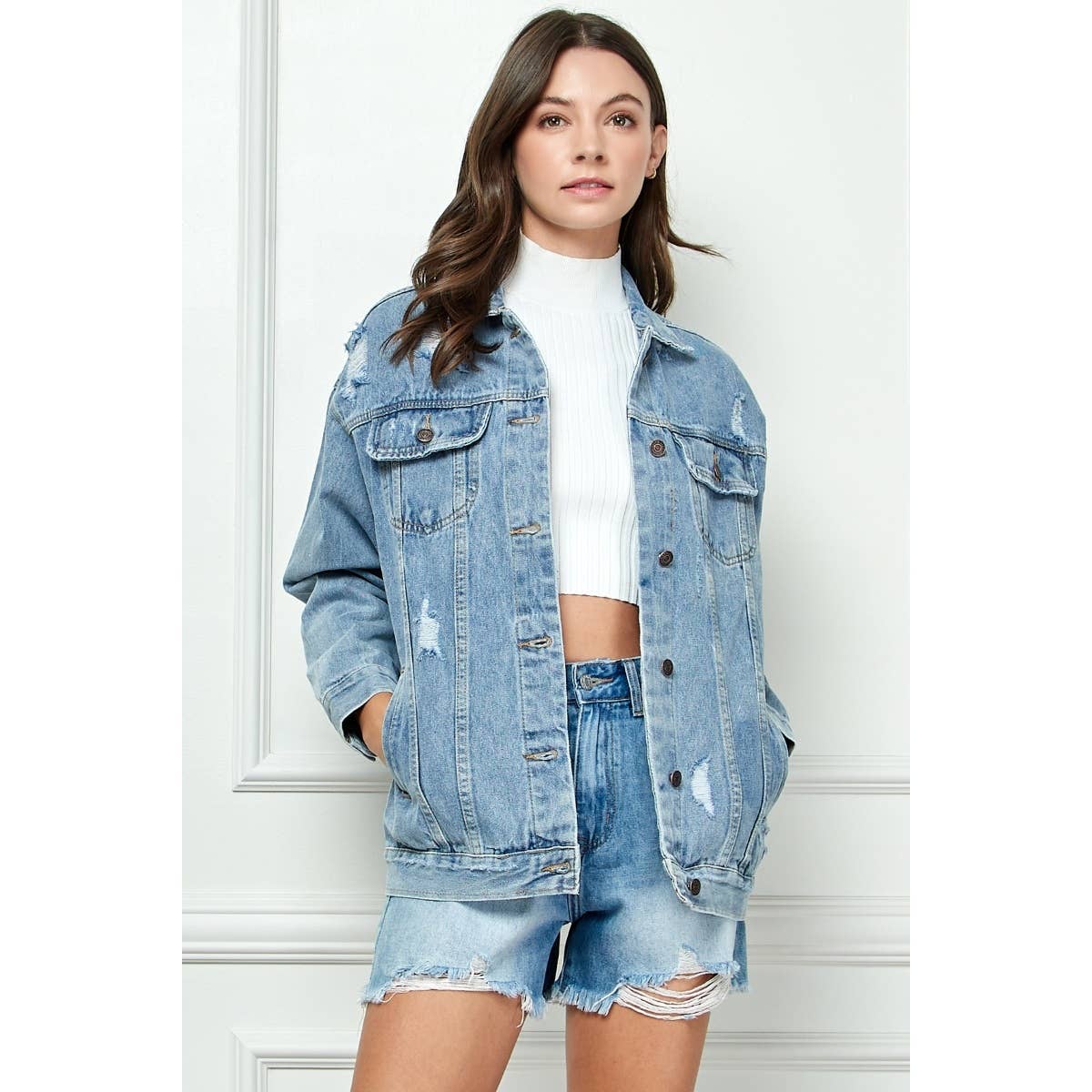 Distressed medium-wash denim jacket with button front and flap chest pockets